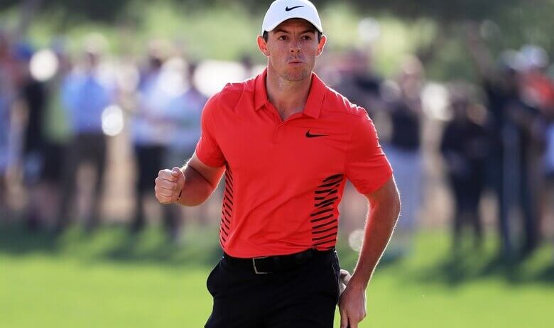 Rory McIlroy pumps his fist after making a putt.