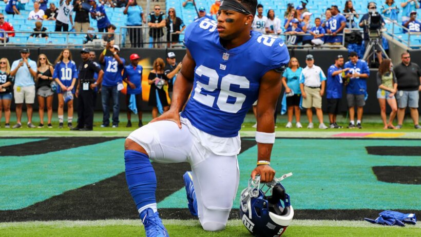 Saquon Barkley takes a knee on the field