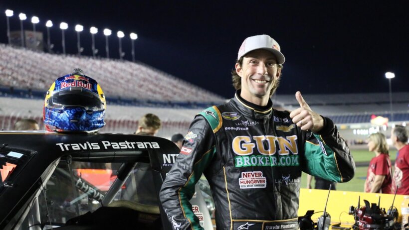 Travis Pastrana posing next to a racecar