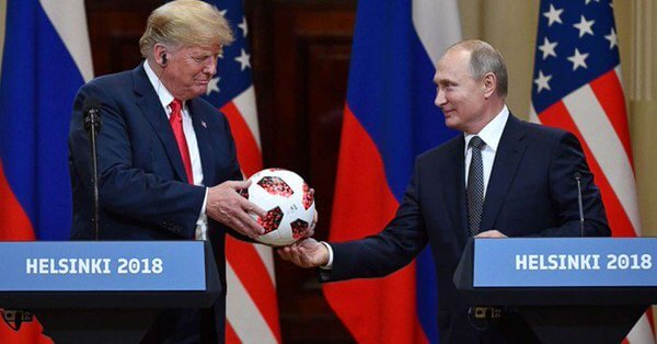 Vladimir Putin gives Donald Trump a soccer ball.